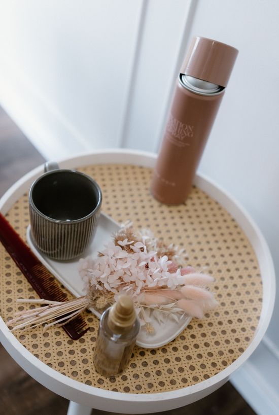 Haircare products, combs and dried flowers arranged on a salon tray