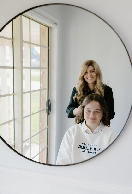 Maree styling a client’s hair in the Honeycombe Hair Studio mirror