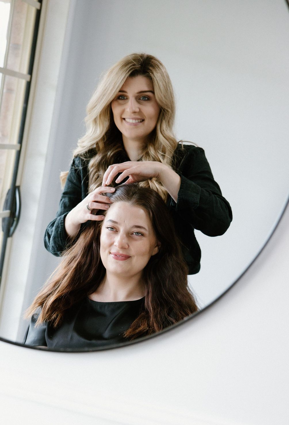Maree standing behind a client reflected in the Honeycombe Hair Studio mirror