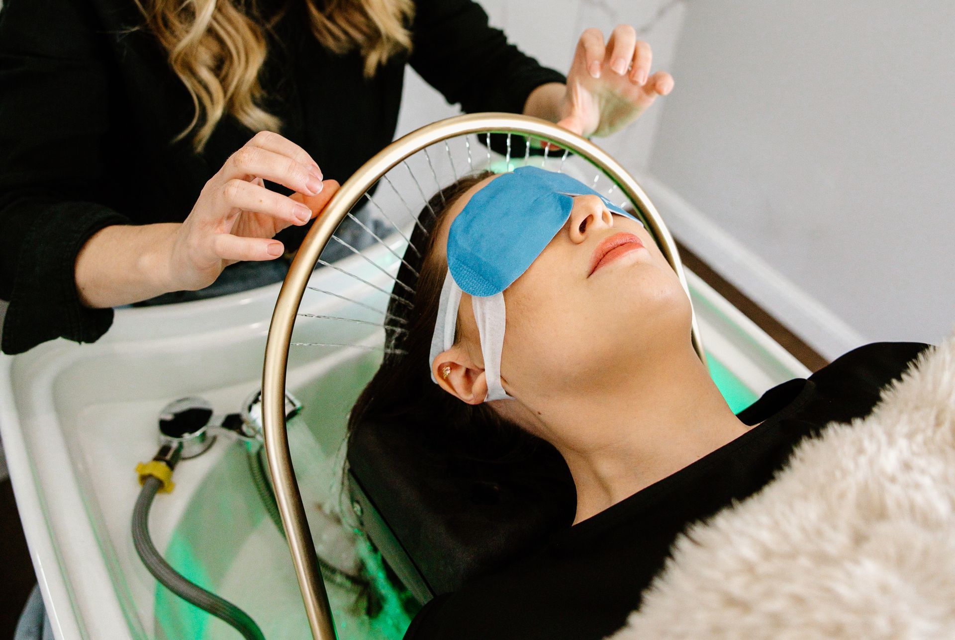 Client relaxing beneath a water halo during a Japanese Head Spa treatment
